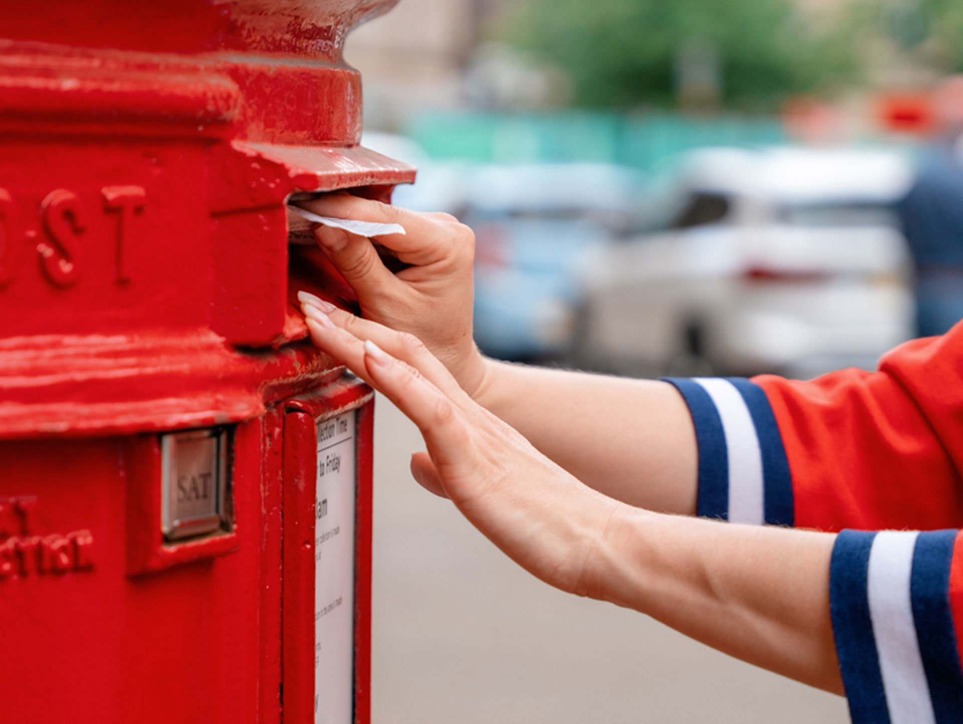 Woman in red jumper posting a letter