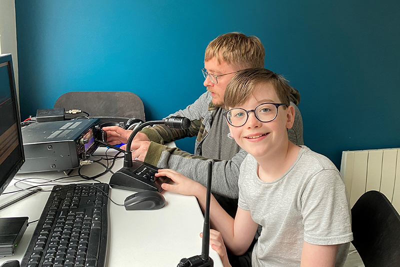 William and his dad William smiles for the camera as he and his dad Michael use their amateur radio equipment and computer together.